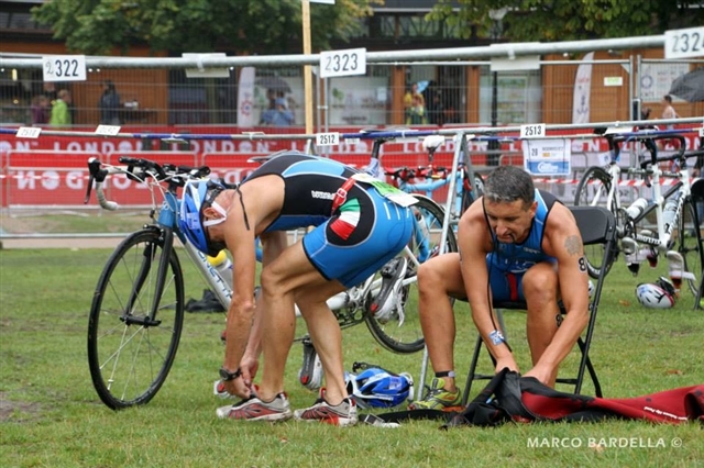 Alberto e Claudio in zona cambio mentre hanno appena finito la frazione in bici e stanno mettendo le scarpe da correre.